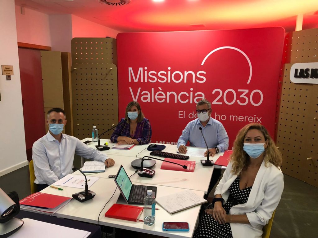 reunión de personas con el logo de Missionas València 2030 detrás